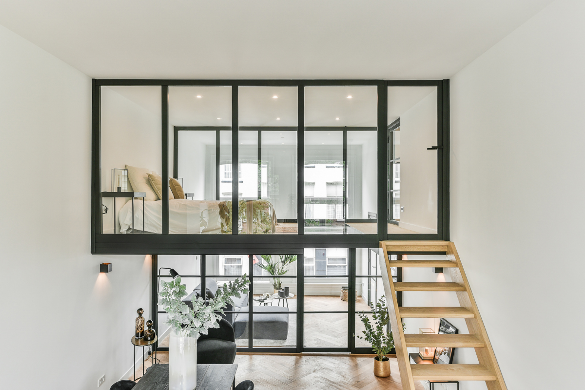 Loft de dos plantas cuya planta superior esta acristalada, podemos observar una habitación en la parte superior, el salón en la inferior.